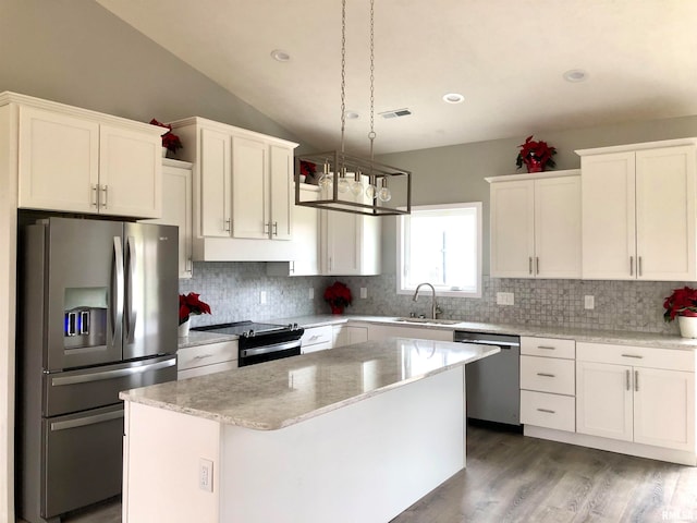 kitchen with pendant lighting, a center island, appliances with stainless steel finishes, and tasteful backsplash