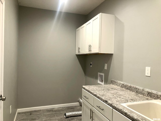 washroom featuring sink, cabinets, hookup for an electric dryer, dark hardwood / wood-style floors, and hookup for a washing machine