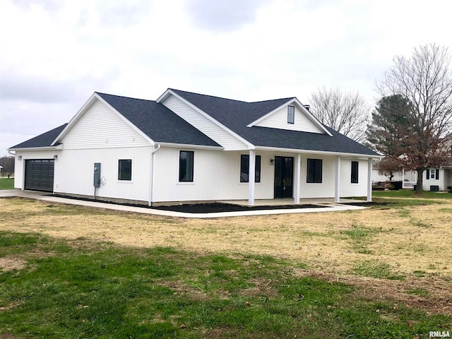 view of front of property with a front yard, a porch, and a garage