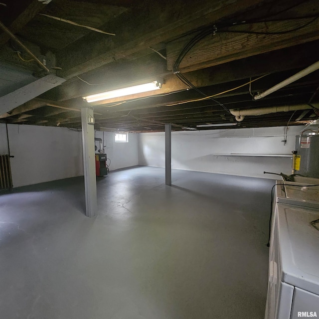 basement featuring electric water heater and washer / dryer