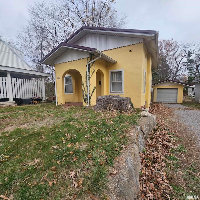 view of front of home featuring a front lawn, an outdoor structure, and a garage