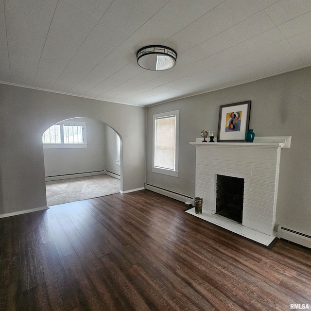 unfurnished living room with a fireplace, a baseboard radiator, dark hardwood / wood-style floors, and crown molding