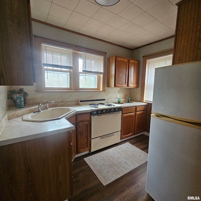 kitchen with white refrigerator, sink, tasteful backsplash, dark hardwood / wood-style flooring, and range