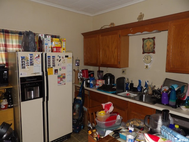 kitchen with white refrigerator with ice dispenser, tile patterned flooring, crown molding, and sink