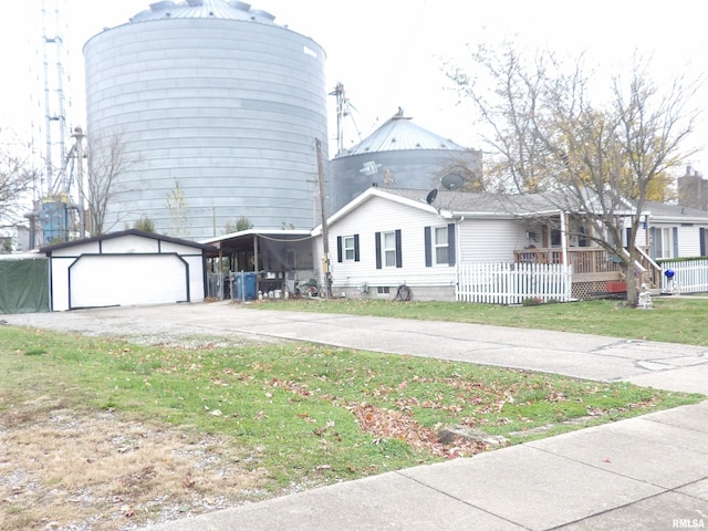 view of front facade featuring a front yard, an outdoor structure, and a garage