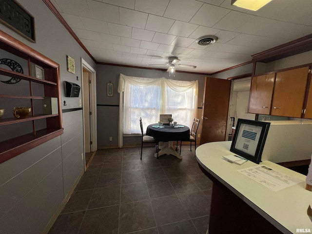 home office with ceiling fan, dark tile patterned floors, and ornamental molding