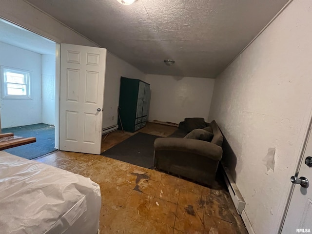 bedroom with baseboard heating, lofted ceiling, and a textured ceiling