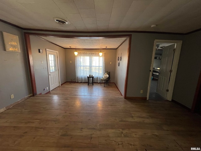 interior space featuring wood-type flooring and ornamental molding