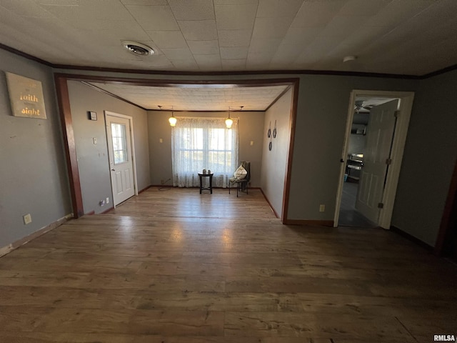 202 S Elm St, Cambria, IL 62915 - unfurnished living room with crown molding, wood finished floors, and baseboards