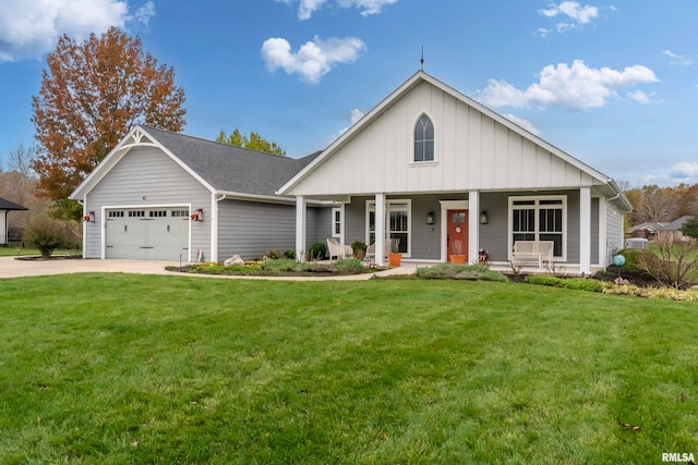 view of front of home with covered porch, a garage, and a front yard