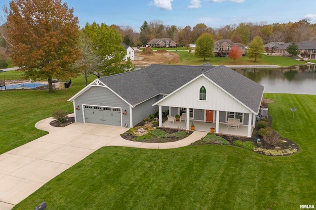 view of front of property featuring a water view, a garage, a porch, and a front yard