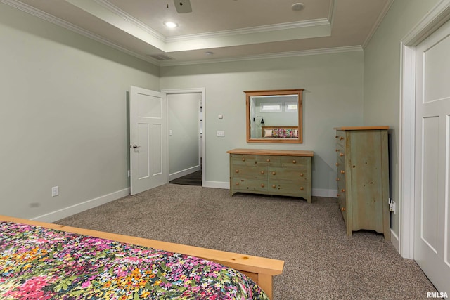 carpeted bedroom with a tray ceiling, ceiling fan, and crown molding