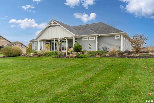 back of house with covered porch and a yard