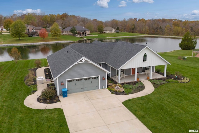 view of front of house with covered porch, a water view, a garage, and a front yard