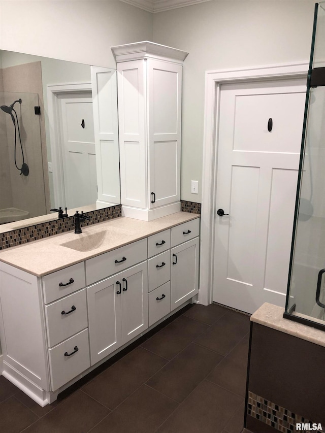 bathroom featuring tile patterned floors, a shower with door, vanity, and ornamental molding