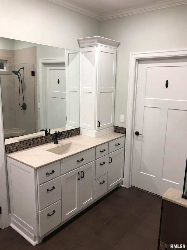 bathroom featuring tile patterned floors, vanity, crown molding, and tiled shower