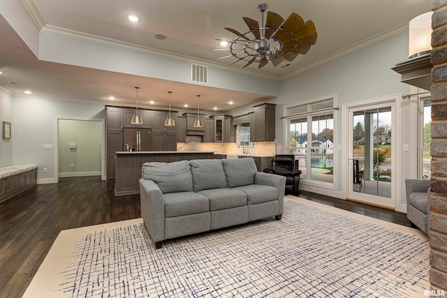 living room with ceiling fan, ornamental molding, and dark wood-type flooring