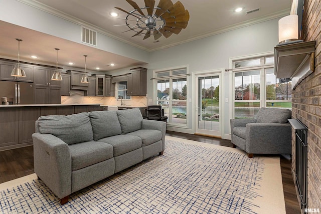 living room featuring hardwood / wood-style floors, ceiling fan, and ornamental molding