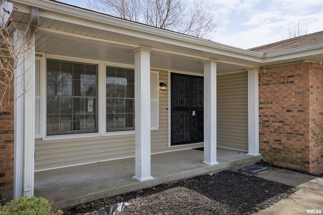 view of exterior entry with brick siding