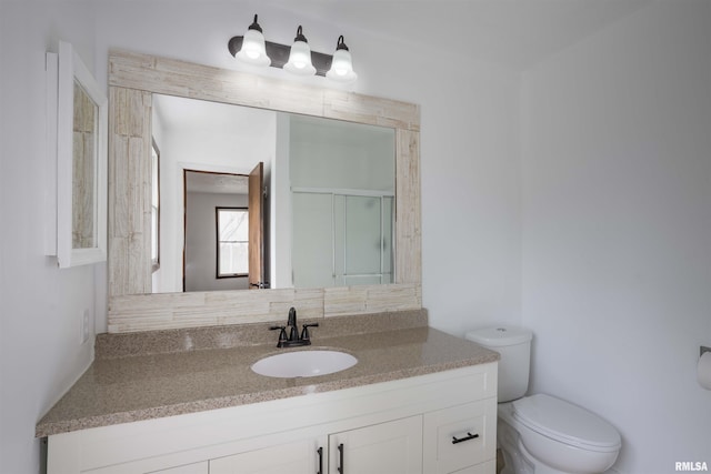 bathroom featuring toilet, a stall shower, and vanity