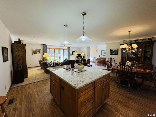 kitchen with decorative light fixtures, a center island, dark hardwood / wood-style floors, and a notable chandelier