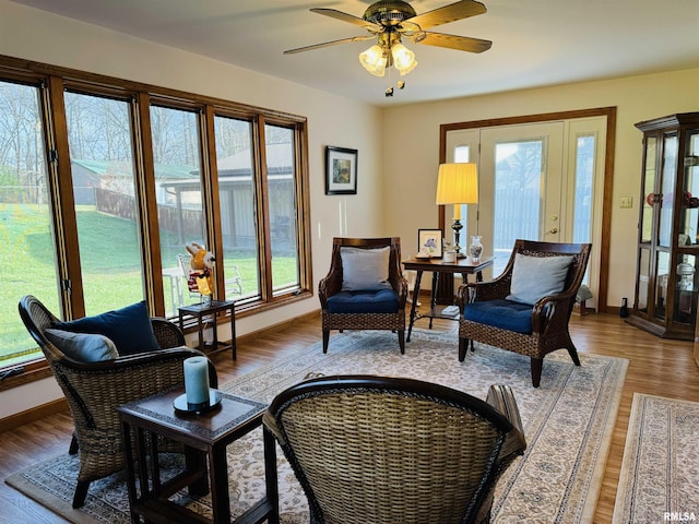 sitting room with a wealth of natural light, ceiling fan, and hardwood / wood-style flooring