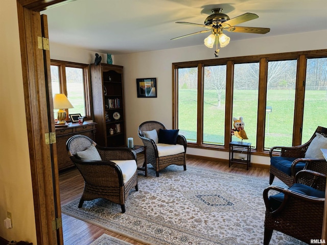 living room featuring a wealth of natural light, ceiling fan, and wood-type flooring