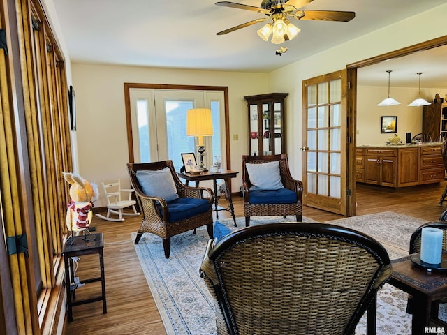 sitting room with ceiling fan, french doors, and light hardwood / wood-style flooring