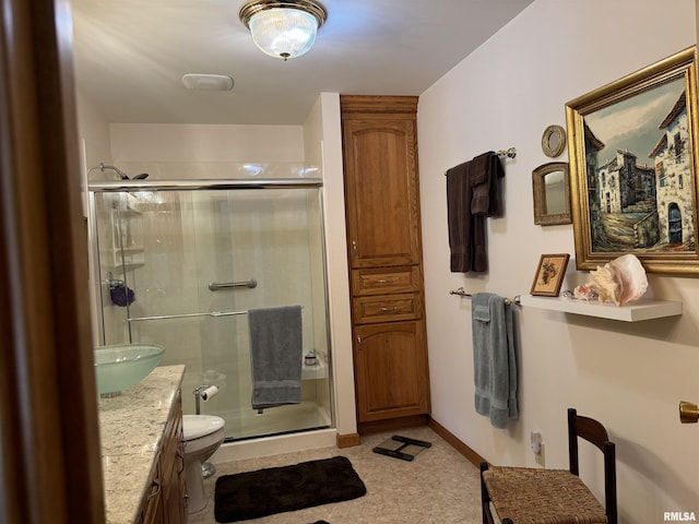 bathroom with vanity, toilet, and a shower with door