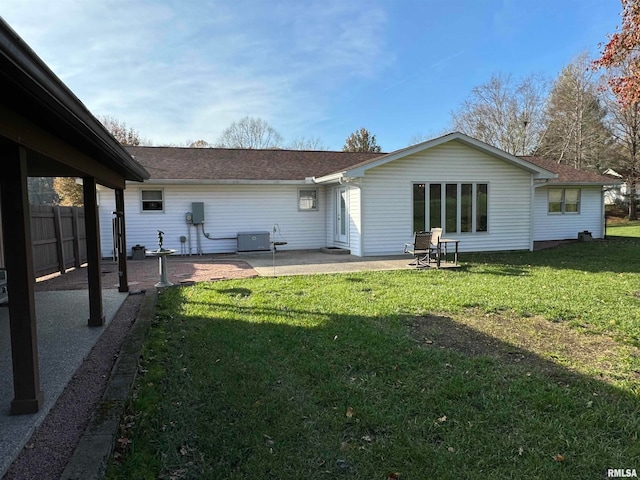 rear view of property with a lawn, a patio area, and central air condition unit