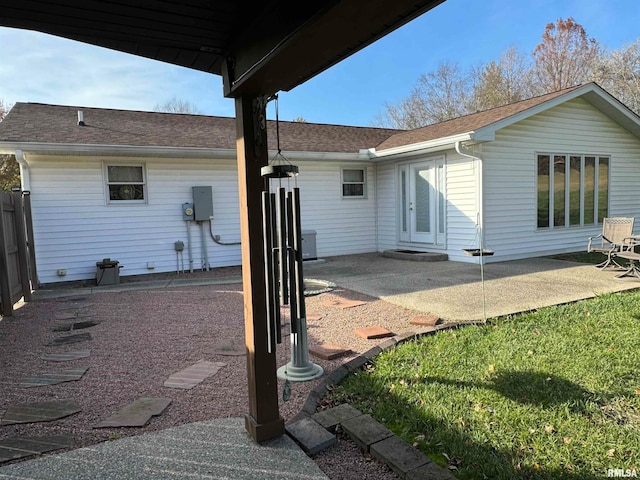 rear view of house featuring a lawn and a patio