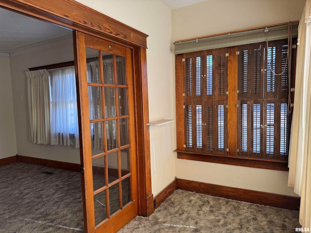 interior space with crown molding, french doors, and dark carpet