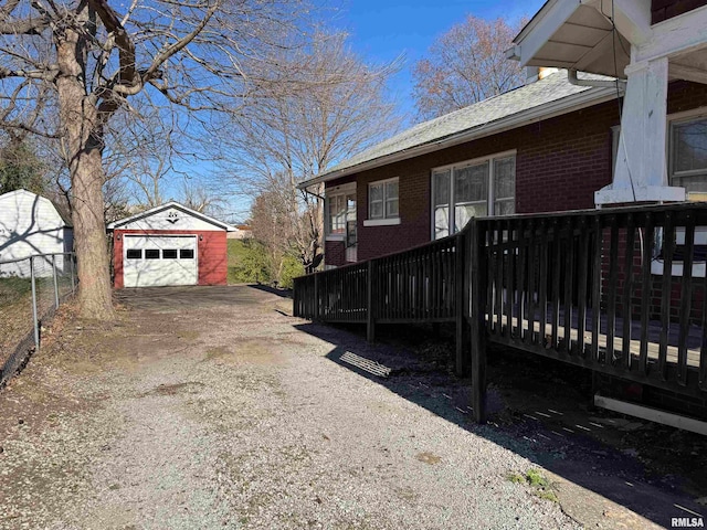 view of property exterior featuring a deck, an outdoor structure, and a garage