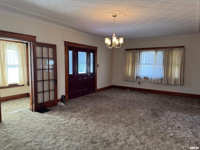 entrance foyer with plenty of natural light, carpet floors, and crown molding