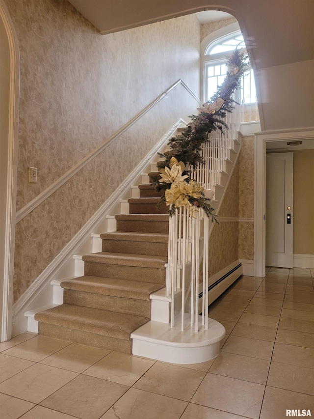 staircase featuring baseboard heating and tile patterned floors