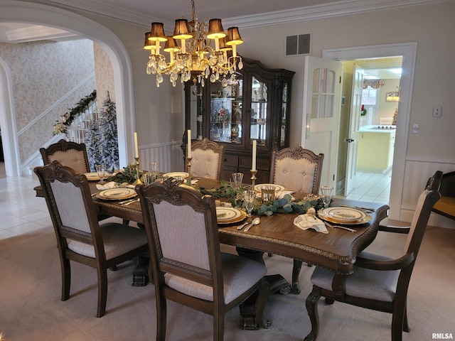 dining space featuring light tile patterned flooring, ornamental molding, and a chandelier