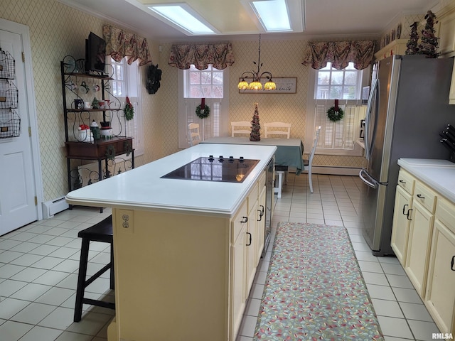 kitchen with black electric stovetop, plenty of natural light, a center island, and a kitchen bar