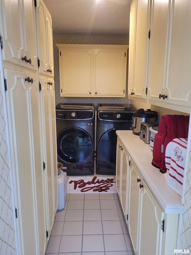 laundry room with light tile patterned flooring, cabinets, and separate washer and dryer