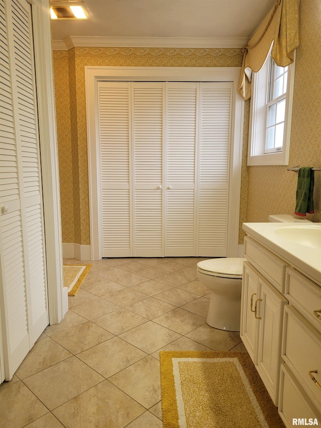 bathroom with tile patterned floors, vanity, toilet, and crown molding