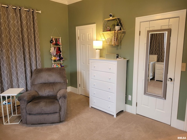 sitting room with crown molding and light carpet