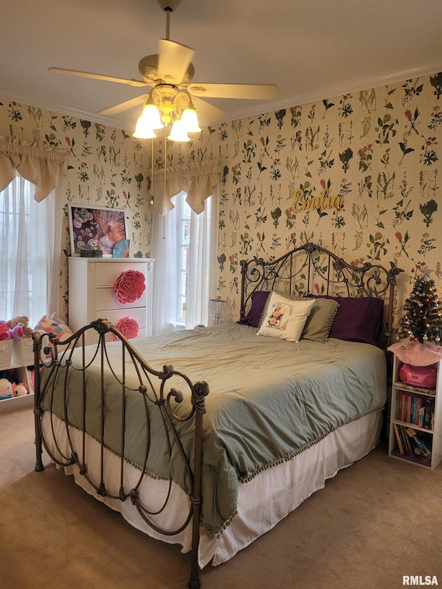 carpeted bedroom with multiple windows, ceiling fan, and ornamental molding