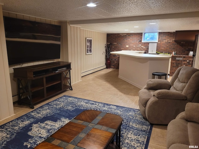 tiled living room with a textured ceiling, baseboard heating, and brick wall