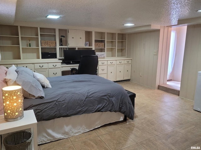 tiled bedroom featuring a textured ceiling and wood walls