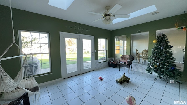 sunroom with a skylight, ceiling fan, and french doors