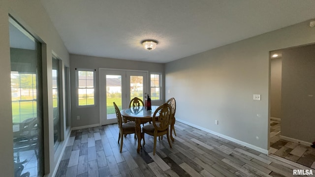 dining room featuring a textured ceiling, hardwood / wood-style floors, and french doors