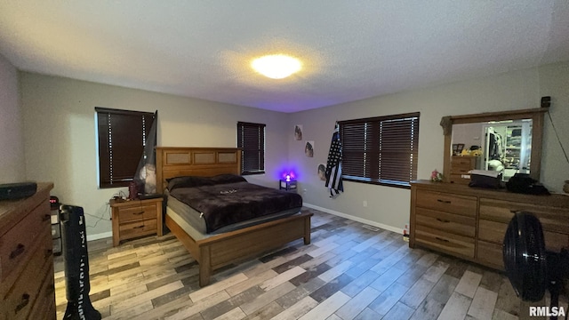 bedroom featuring light hardwood / wood-style floors and a textured ceiling