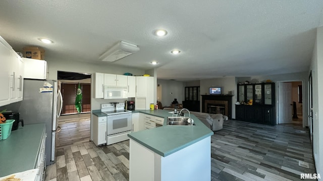 kitchen with white appliances, white cabinetry, and sink