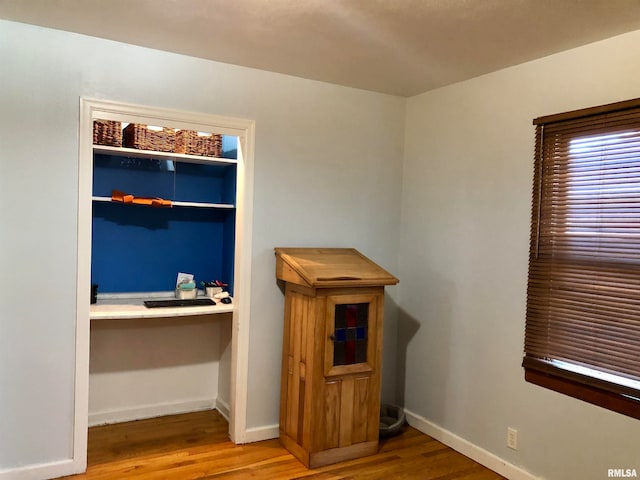 interior space with hardwood / wood-style flooring and built in desk