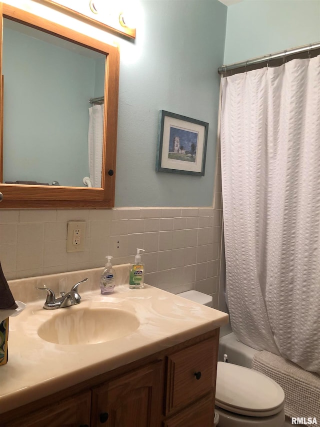 full bathroom with vanity, shower / tub combo, tile walls, and toilet