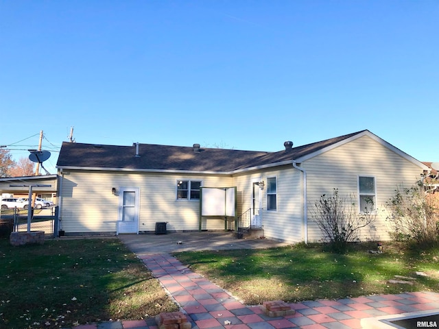 back of property with a lawn and a patio